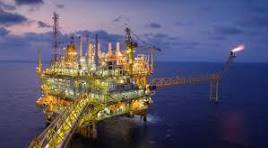 Professional oil rig workers operating rotary drilling equipment in Texas oil field - Elite Wealth Capital energy investments